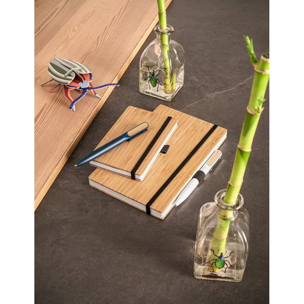 Caderno de bolso com capa e contracapa em placa de bambu e lombada em PET 100% reciclado, com 160 páginas lisas